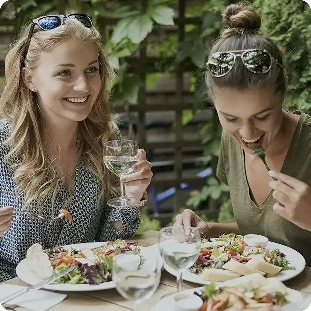 Two girls eating a meal together.
