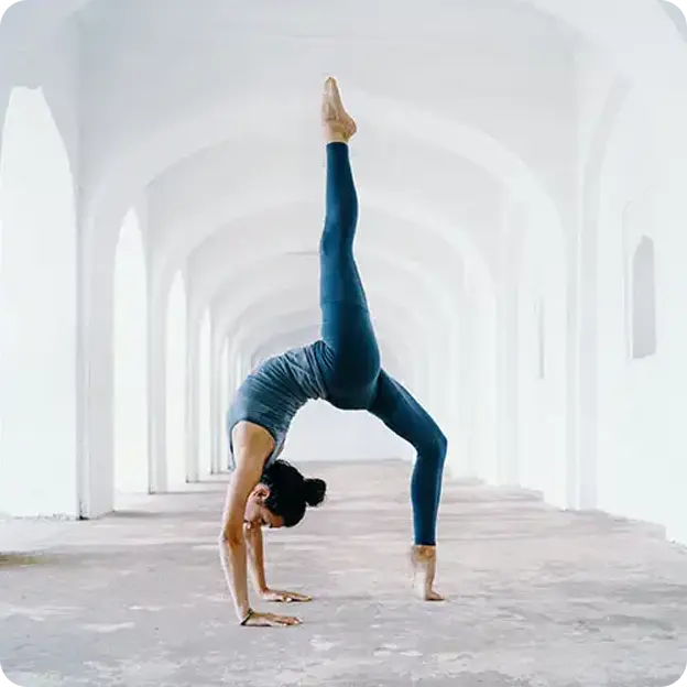 Woman doing yoga poses in an alley.