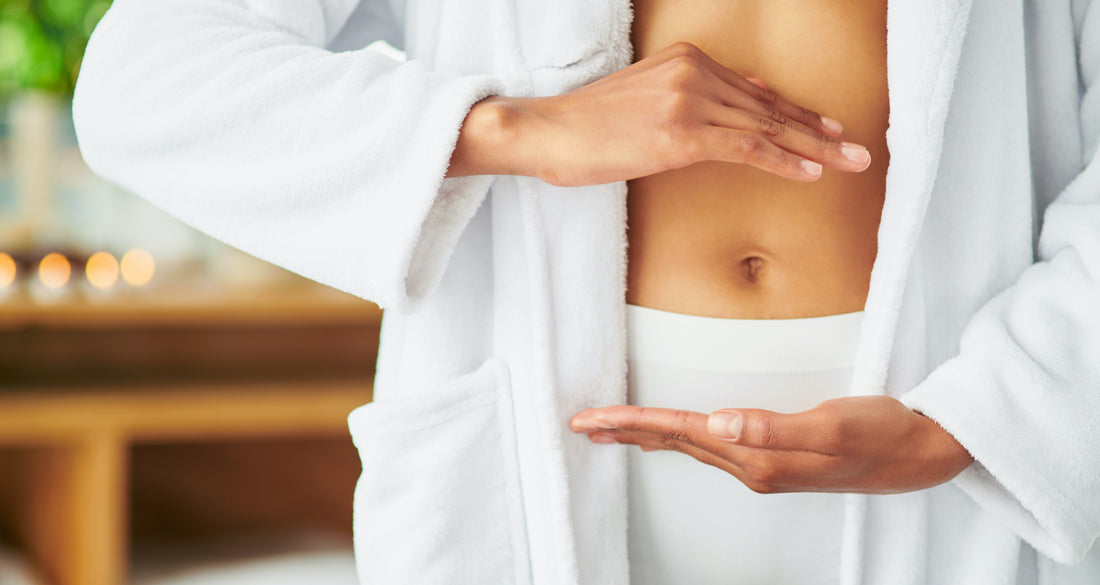 A woman showing her stomach in a display of the benefits of proteolytic enzymes