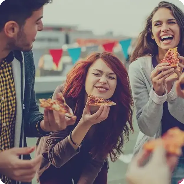 Group of people eating pizza together.