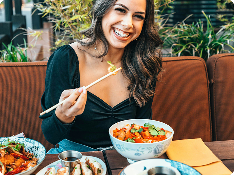 Woman smiling eating food.