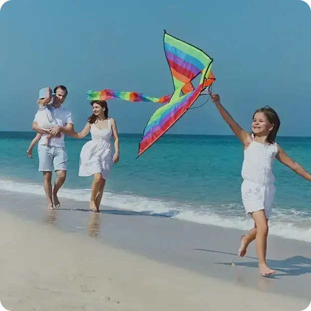 Family flying a kite on the beach.