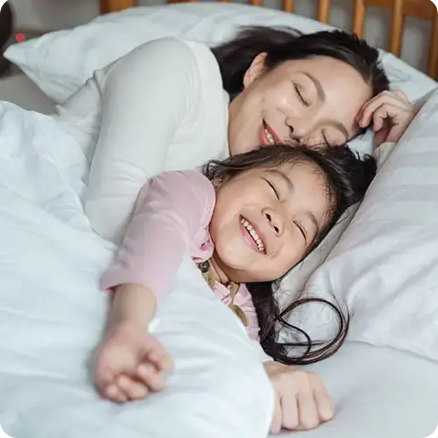 Mother and Daughter cuddling in bed.