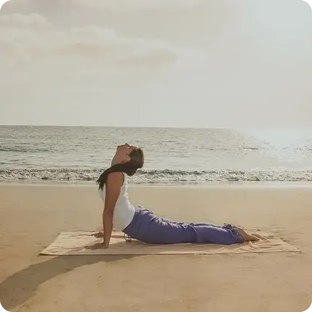 Woman doing yoga on a beach.
